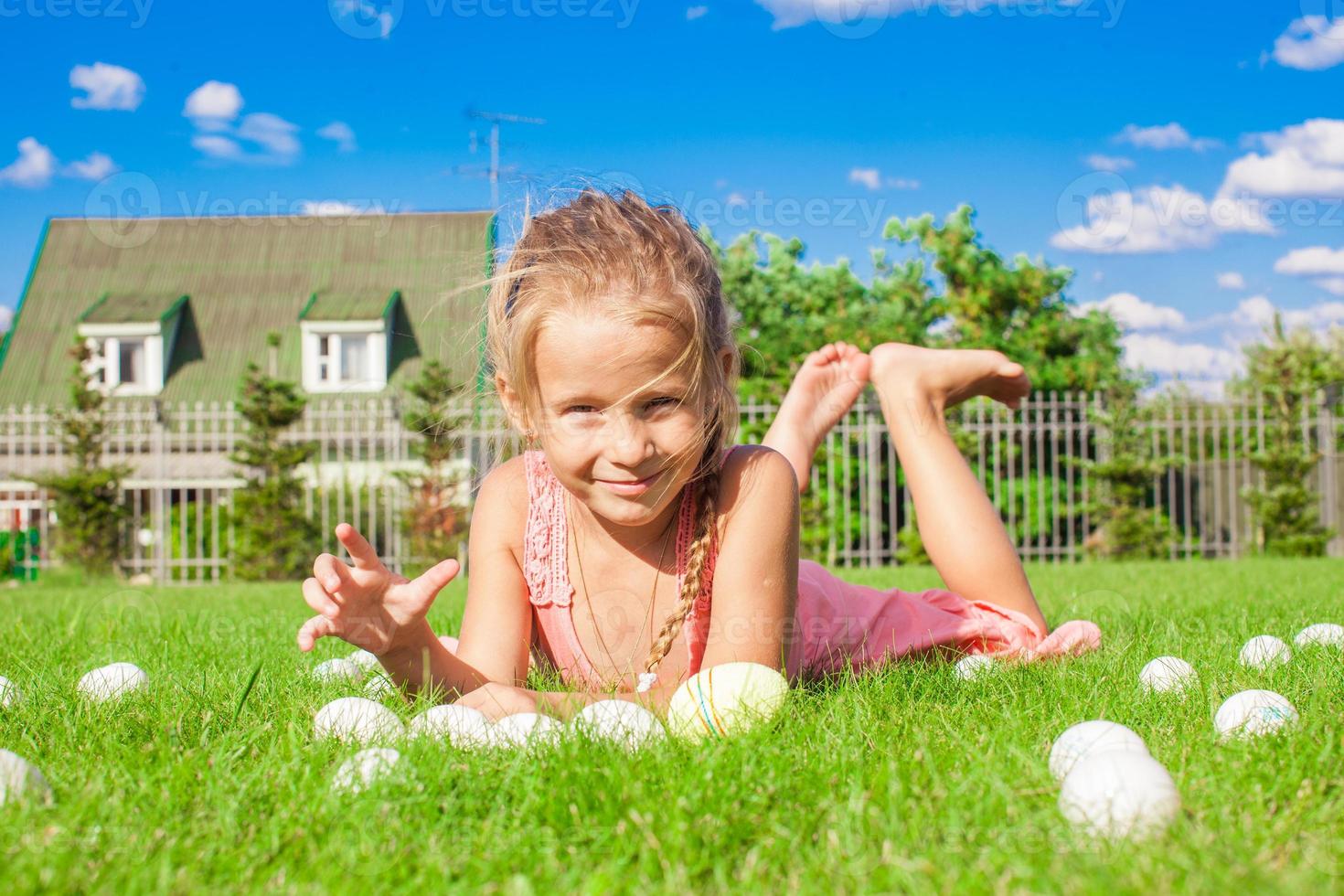 poco adorabile ragazza giocando con bianca Pasqua uova nel il cortile foto