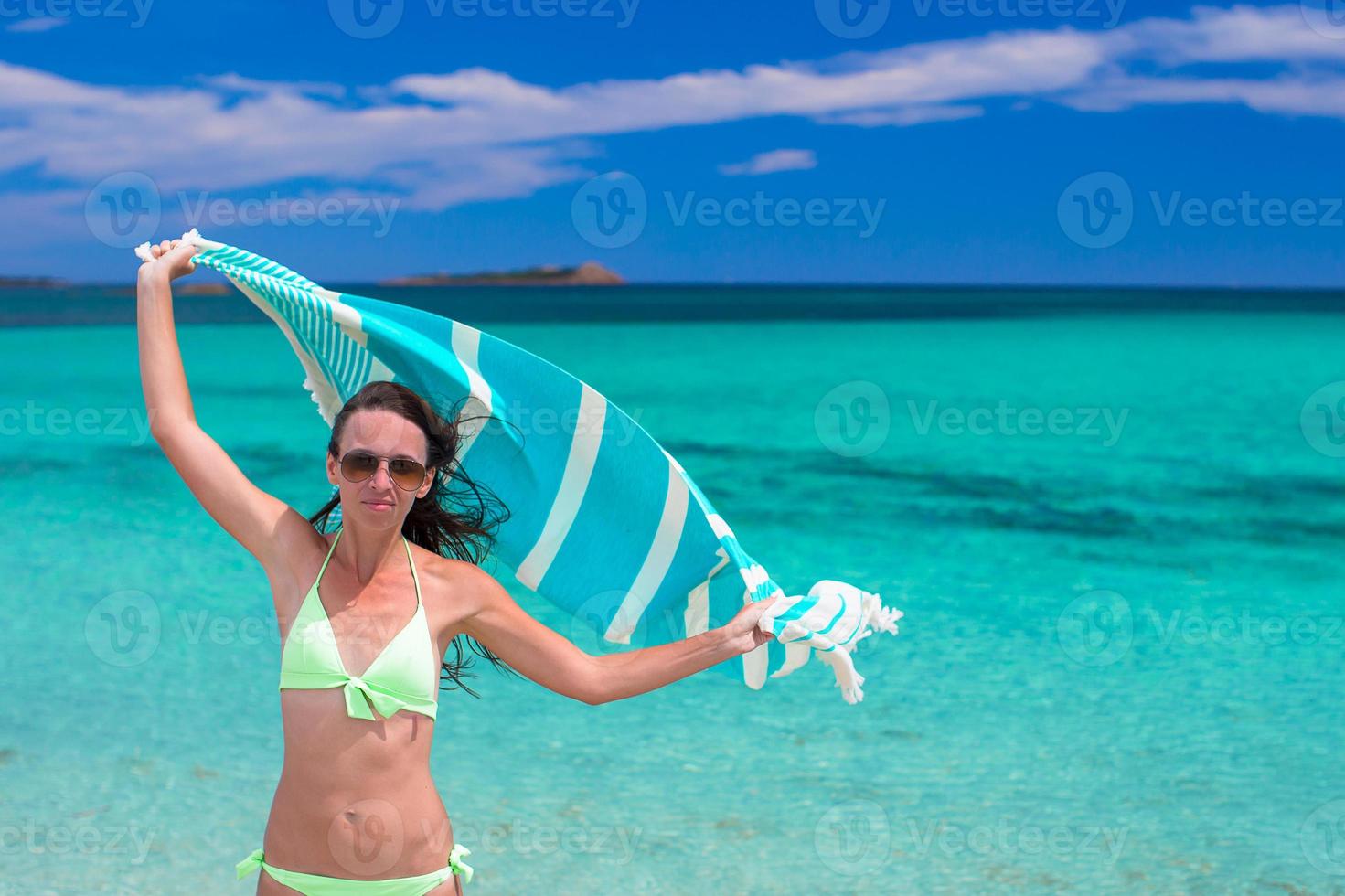 contento donna avere divertimento con spiaggia asciugamano e molto contento foto