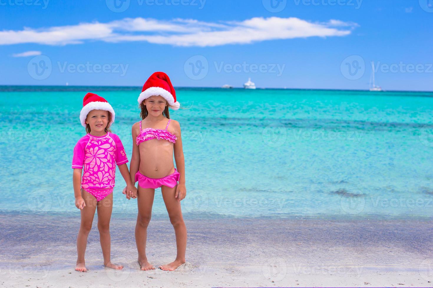 poco ragazze nel Santa cappelli durante estate vacanza foto