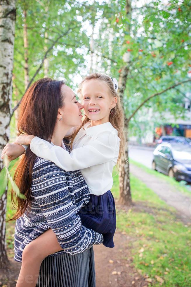 madre porta sua figlia per scuola. adorabile poco ragazza sensazione molto eccitato di andando indietro per scuola foto