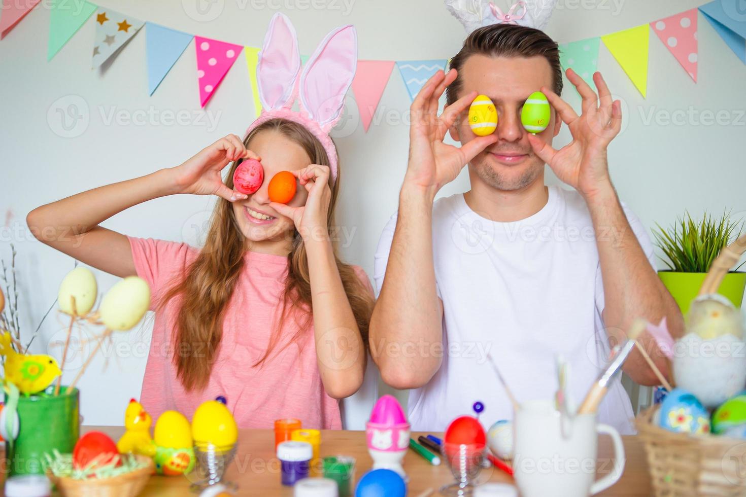 padre e il suo poco figlia pittura uova. contento famiglia preparazione per Pasqua. foto