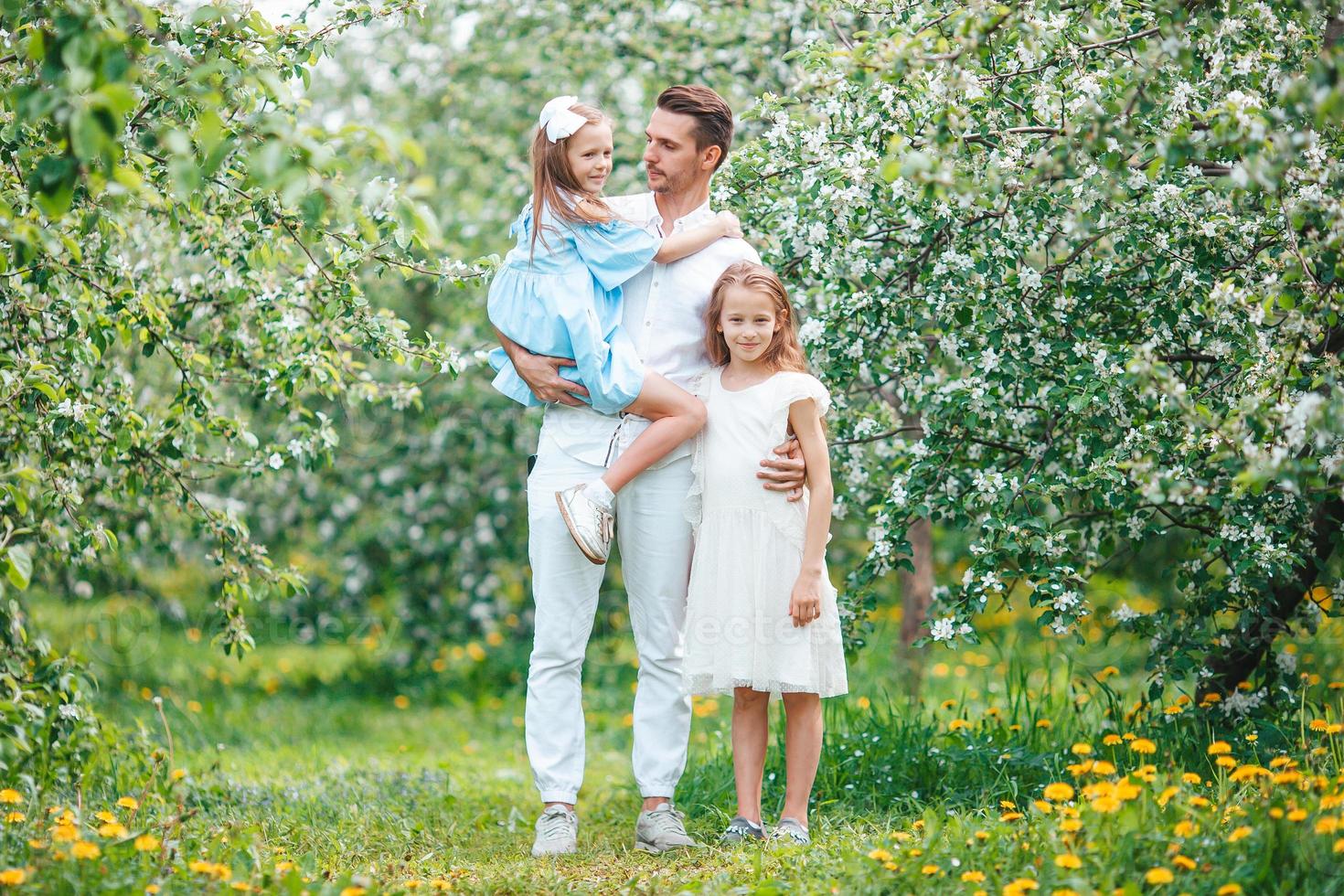 adorabile famiglia nel fioritura ciliegia giardino su bellissimo primavera giorno foto