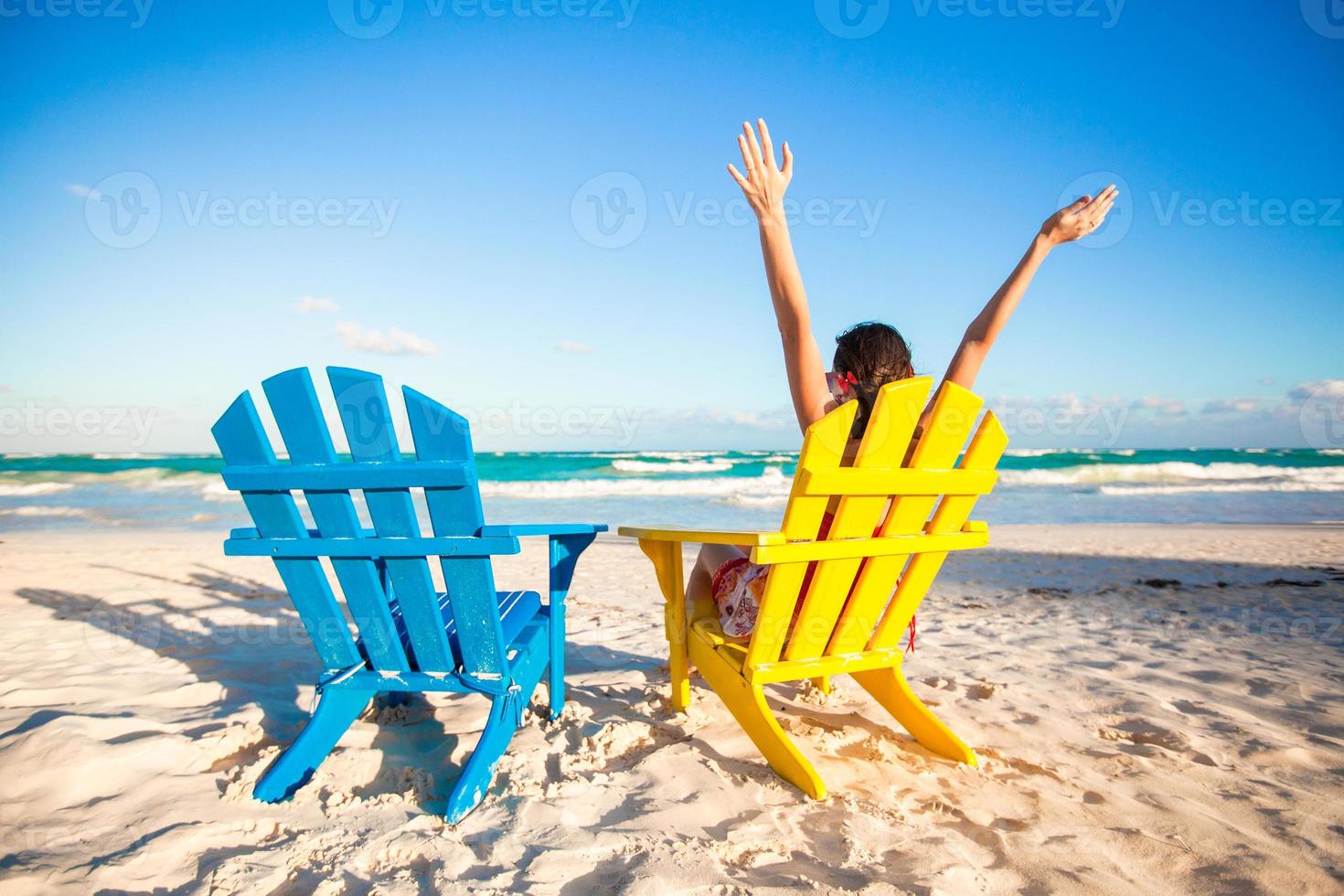 giovane donna nel spiaggia sedia sollevato sua mani su foto