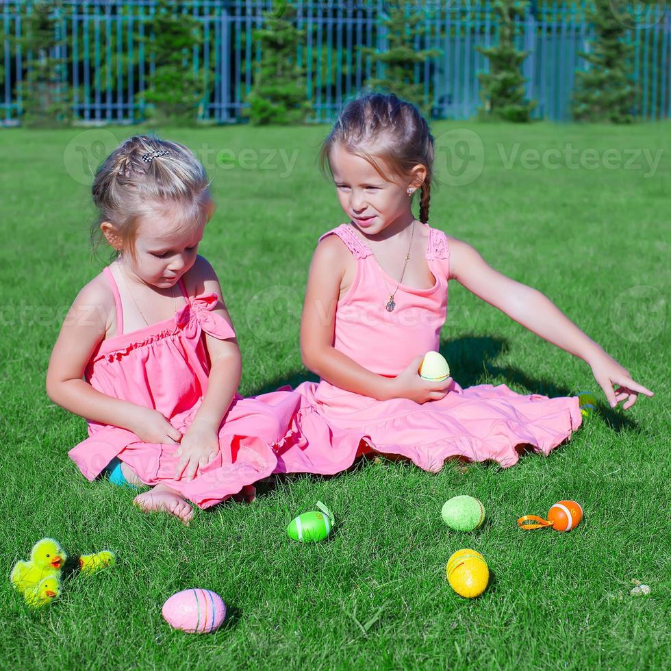 Due adorabile poco ragazze giocando con Pasqua uova su verde erba foto