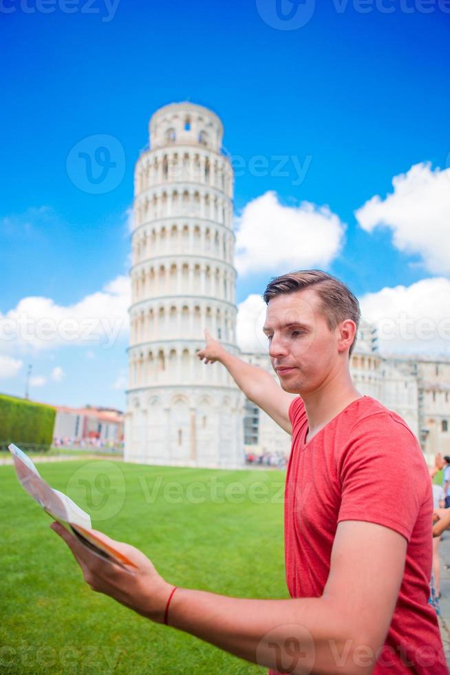 giovane ragazzo con turistico carta geografica su viaggio per pisa. turista in viaggio visitare il pendente Torre di pisa. foto
