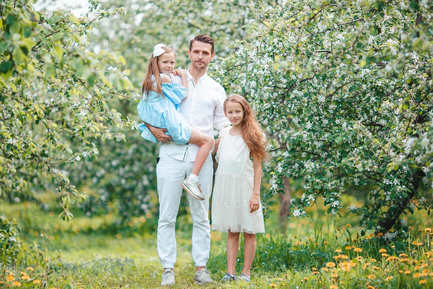 adorabile famiglia nel fioritura ciliegia giardino su bellissimo primavera giorno foto