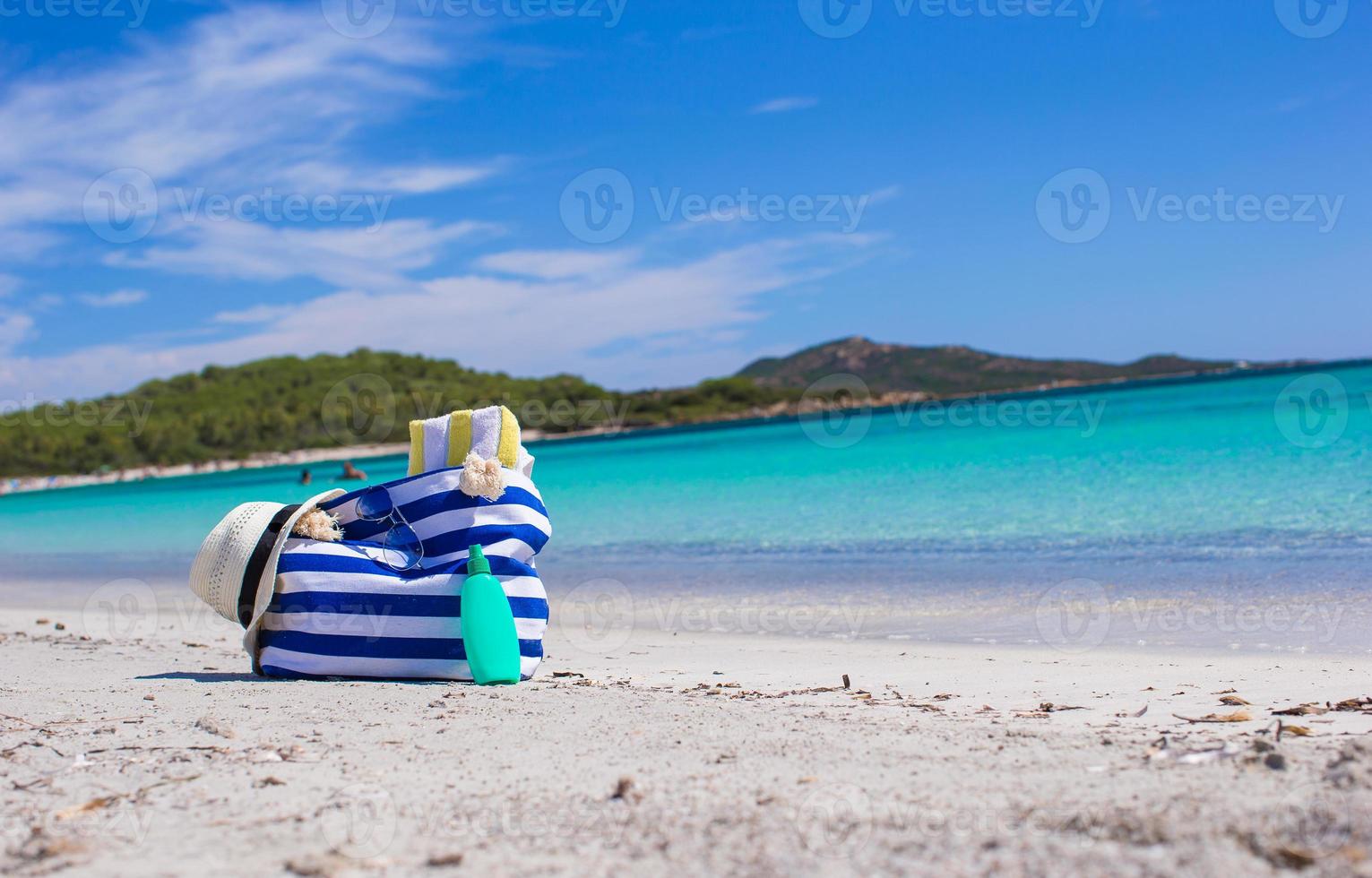 banda Borsa, cannuccia cappello, crema solare e frisbee su bianca sabbioso tropicale spiaggia foto