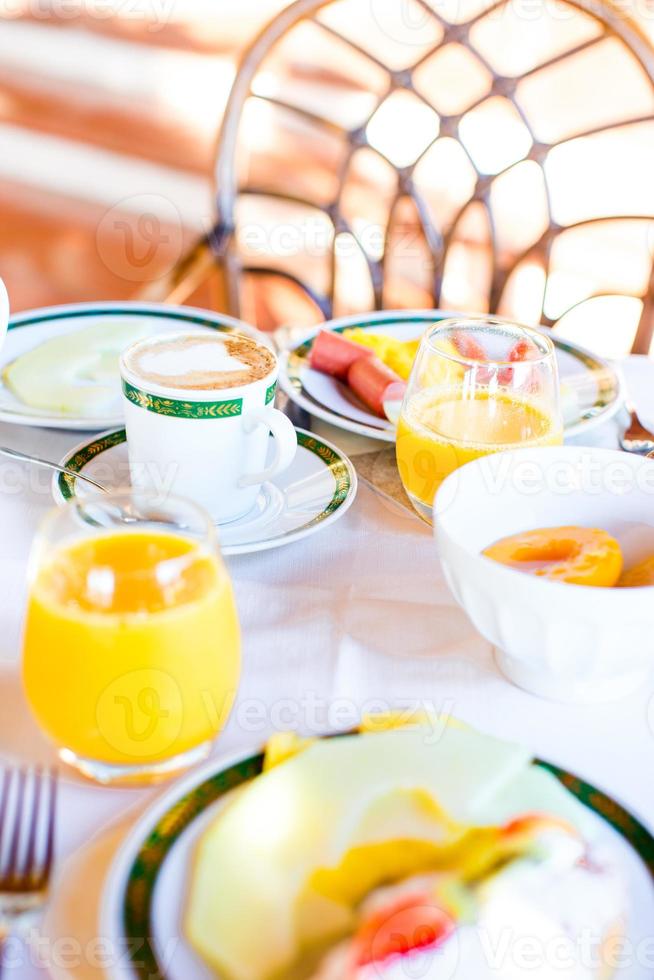 salutare prima colazione con fresco succo e dolce brioche nel ristorante ricorrere all'aperto foto