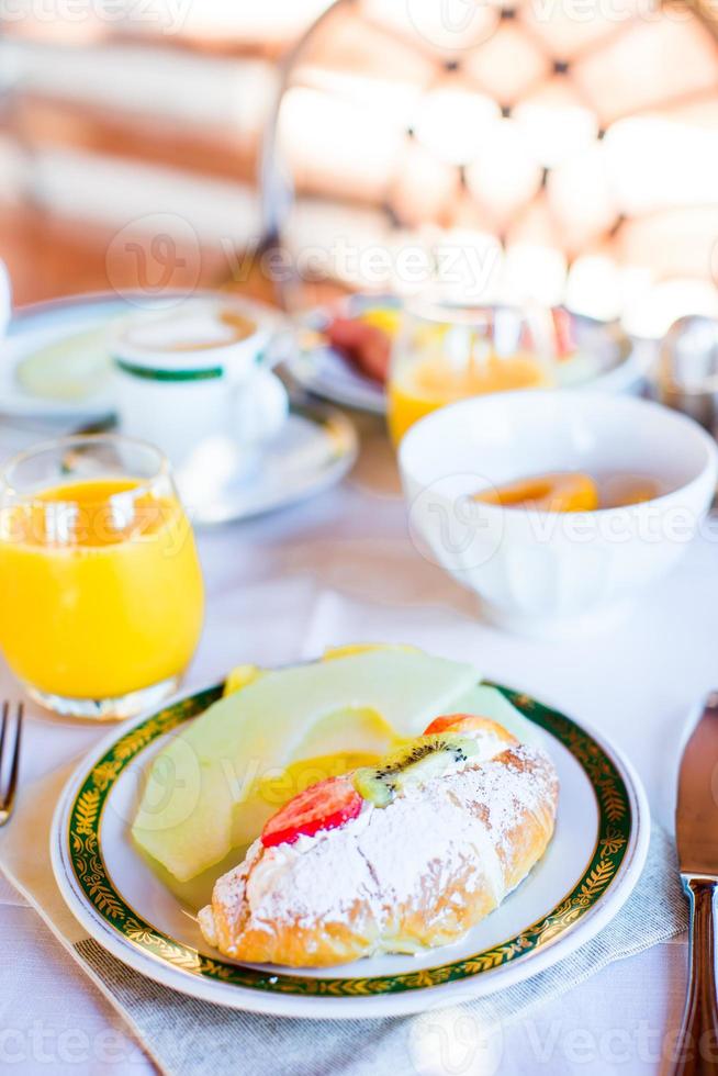 salutare prima colazione con fresco succo e dolce brioche nel ristorante ricorrere all'aperto foto