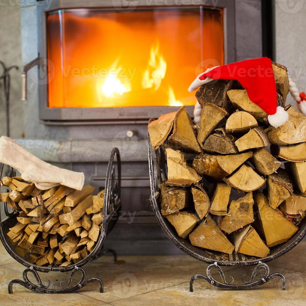 legna da ardere con Santa Claus cappello nel il Casa vicino un' camino foto