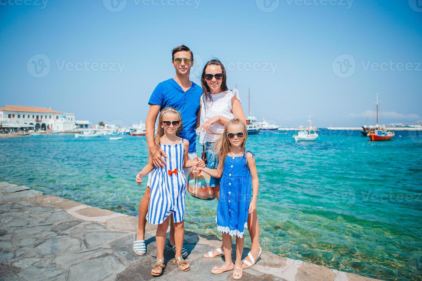 genitori e bambini a strada di tipico greco tradizionale villaggio su mykonos isola, nel Grecia foto