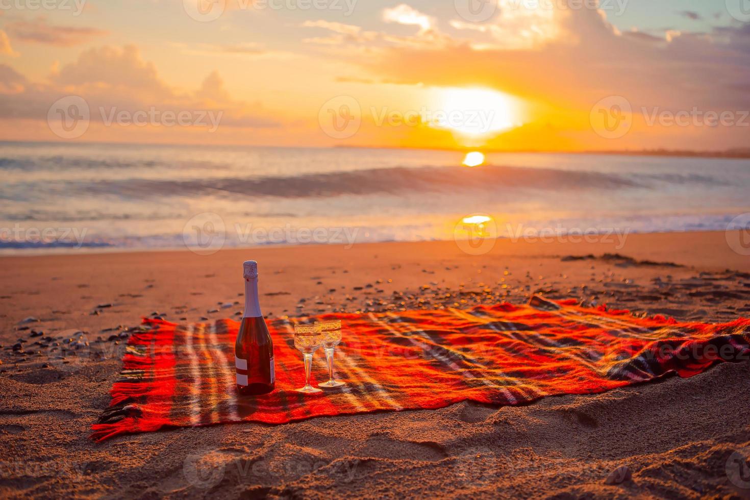 avendo un' picnic su il spiaggia a tramonto foto