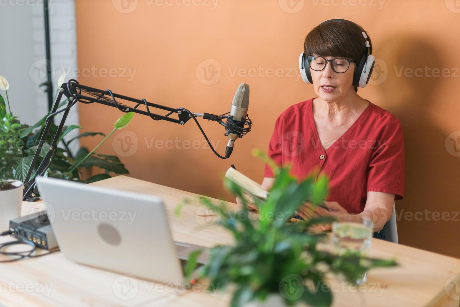 di mezza età femmina Radio presentatore parlando in il microfono e lettura notizia - Radio trasmissione in linea concetto foto