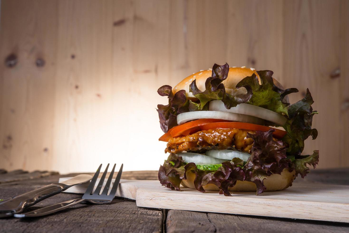 hamburger di pollo fatto in casa con lattuga, pomodoro e cipolla foto