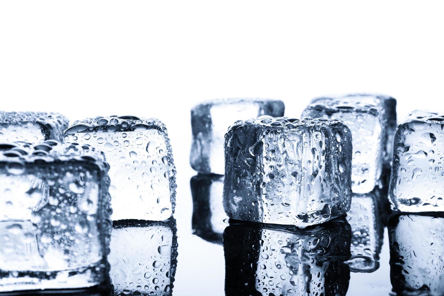 primo piano di cubetti di ghiaccio bagnati su sfondo minimo foto