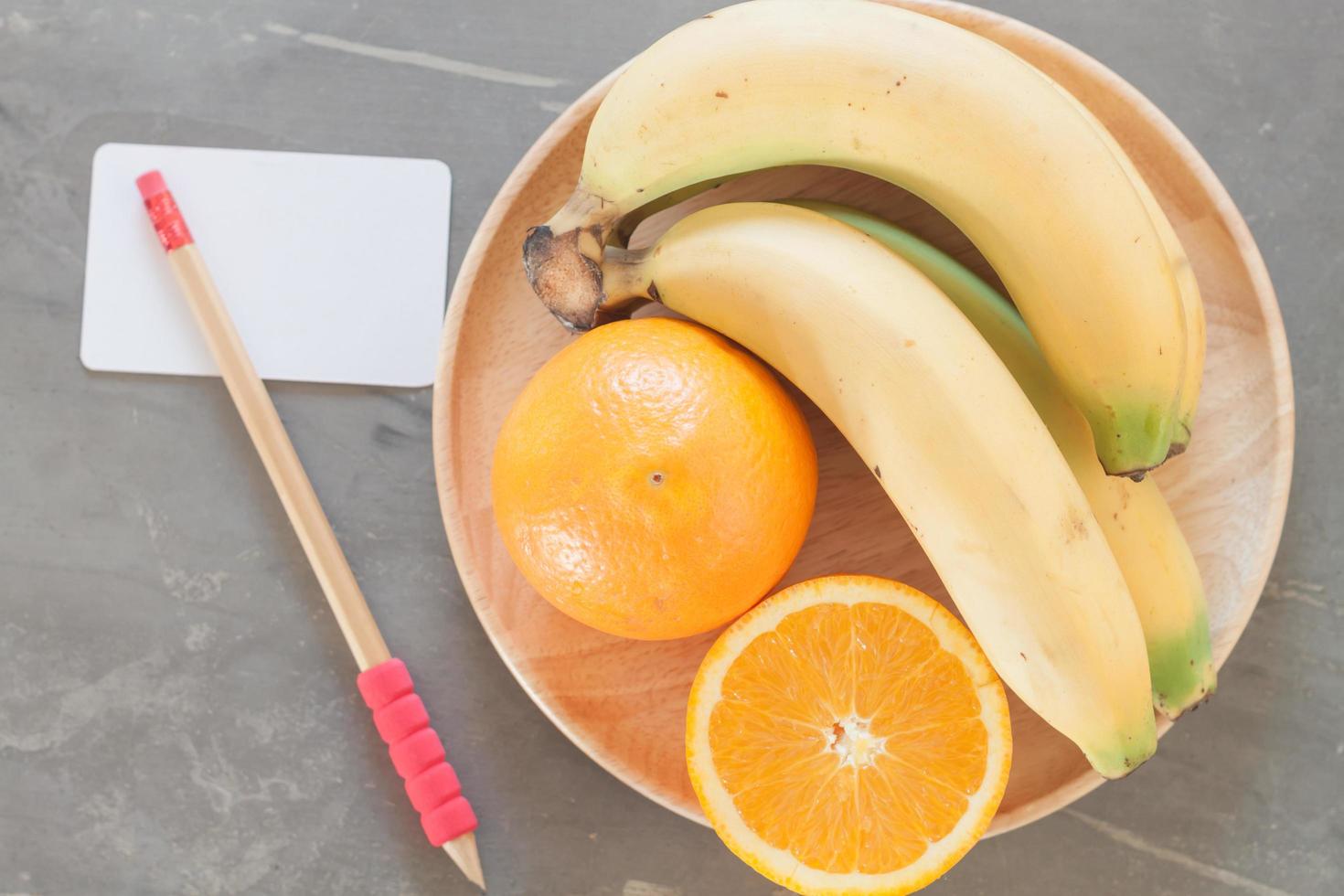 ciotola di frutta con una matita e un biglietto da visita foto