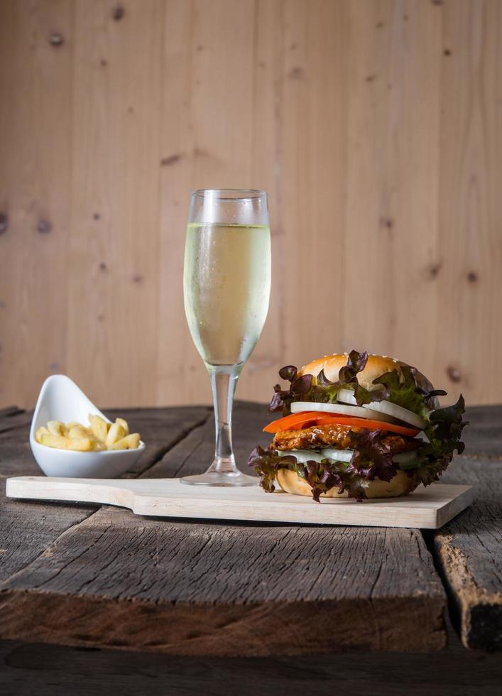 hamburger di pollo fatto in casa con champagne e patatine fritte foto