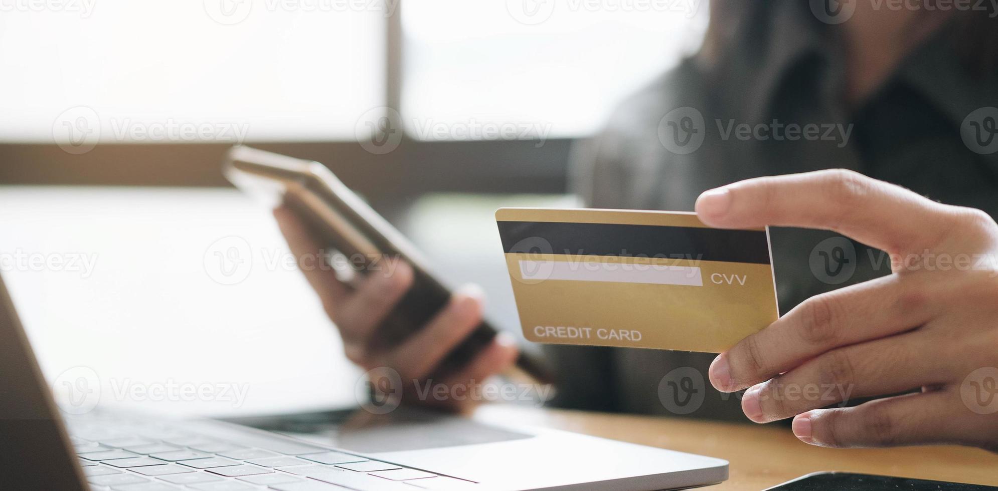 mani che tengono la carta di credito e utilizzando laptop foto