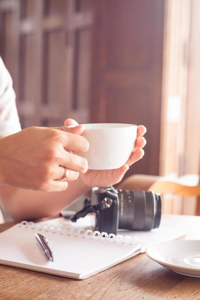 primo piano di una persona che tiene una tazza di caffè foto