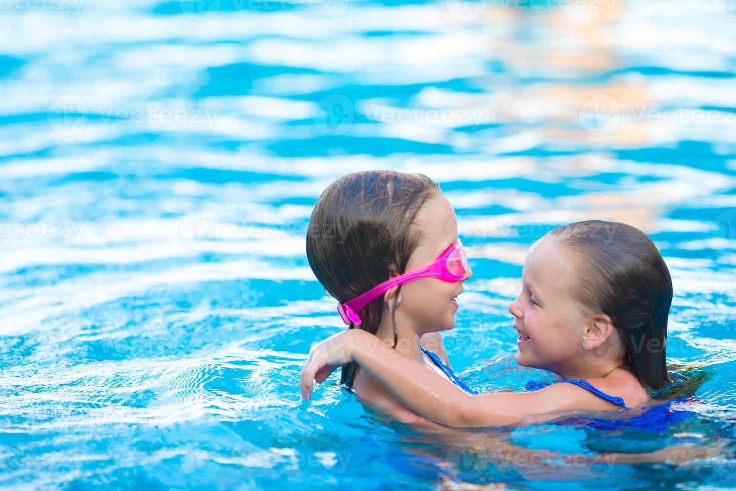 adorabili bambine che giocano nella piscina all'aperto foto