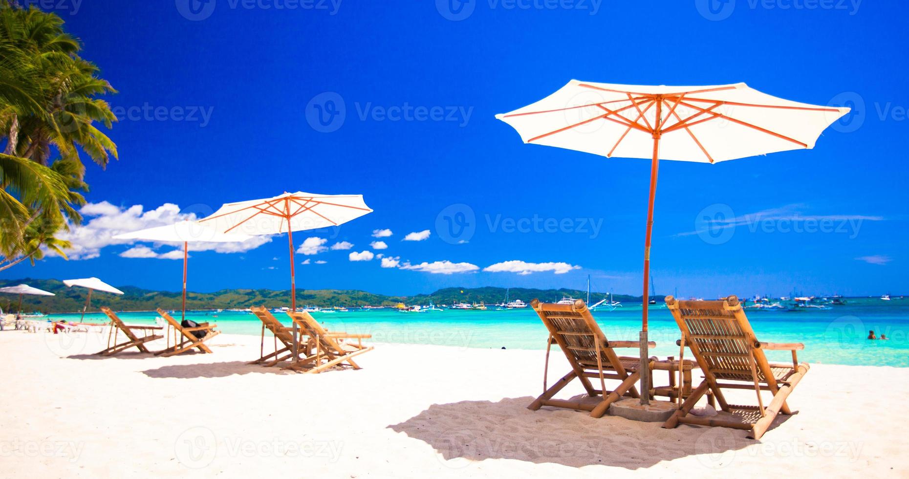 sedie a sdraio sulla spiaggia di sabbia bianca tropicale esotica foto