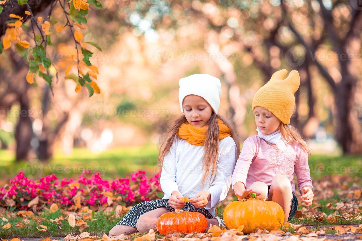 poco adorabile ragazze con zucca all'aperto su un' caldo autunno giorno. foto