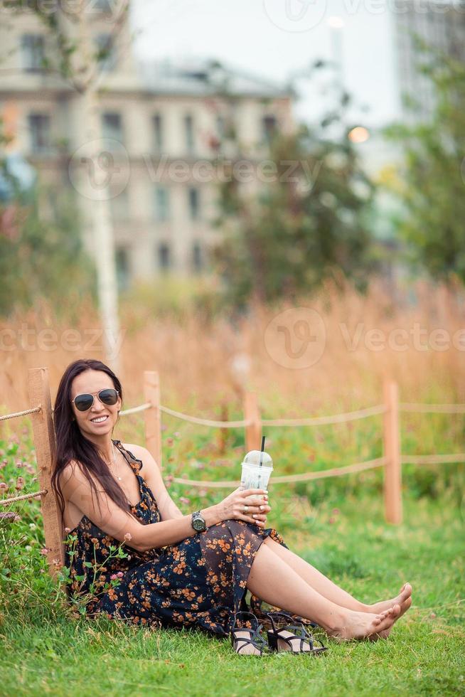 contento giovane urbano donna potabile caffè all'aperto foto