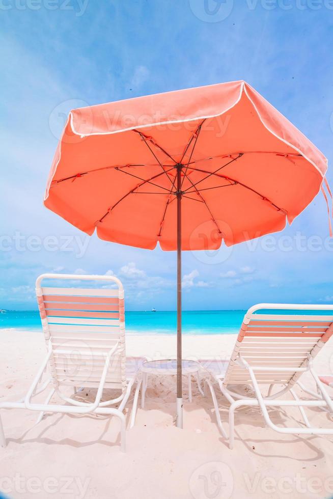 lettini e ombrelli a bianca spiaggia su il riva del mare foto