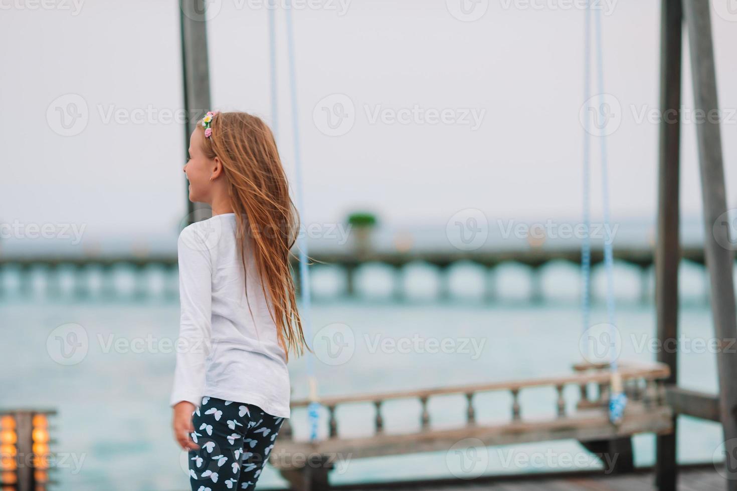 bambina adorabile che gioca sulla spiaggia con la palla foto