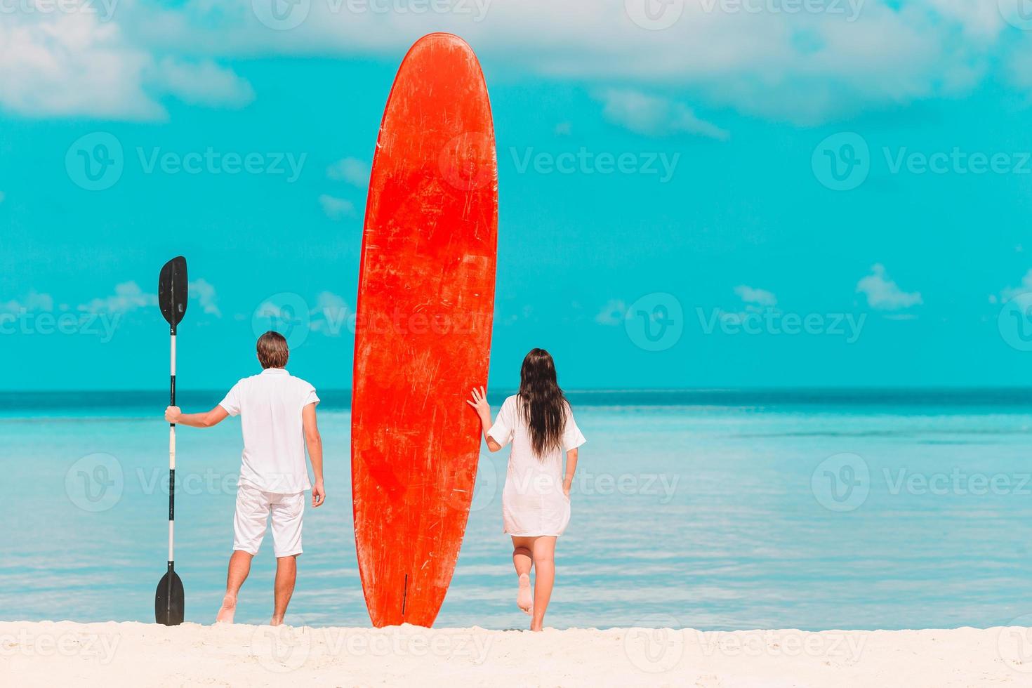 giovane coppia con rosso tavola da surf durante tropicale vacanza foto