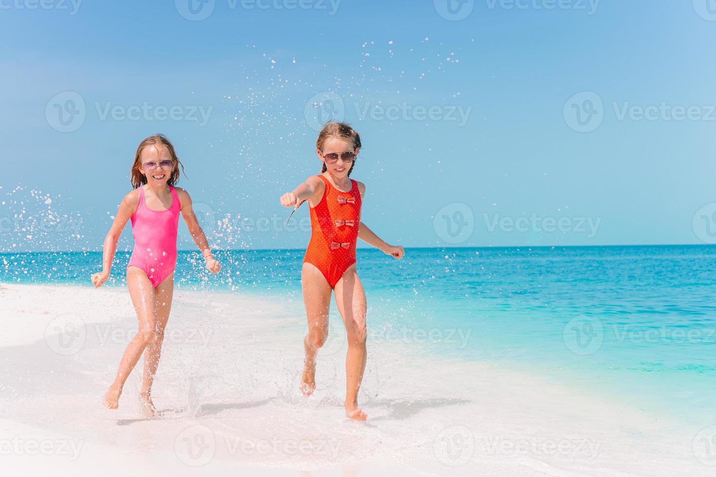 adorabile poco ragazze avere un' lotto di divertimento su il spiaggia. foto