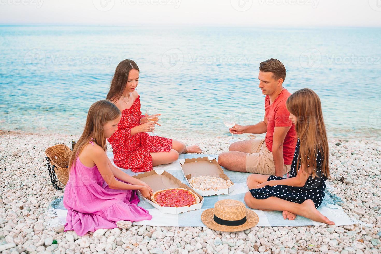 famiglia avendo un' picnic su il spiaggia foto