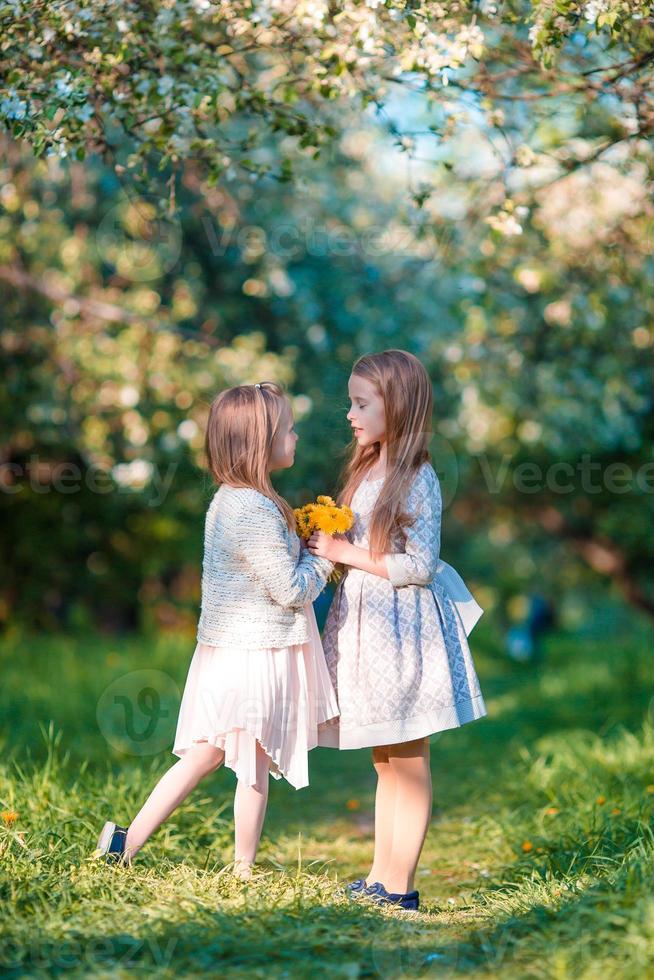 adorabile ragazze nel fioritura Mela giardino su soleggiato primavera giorno foto