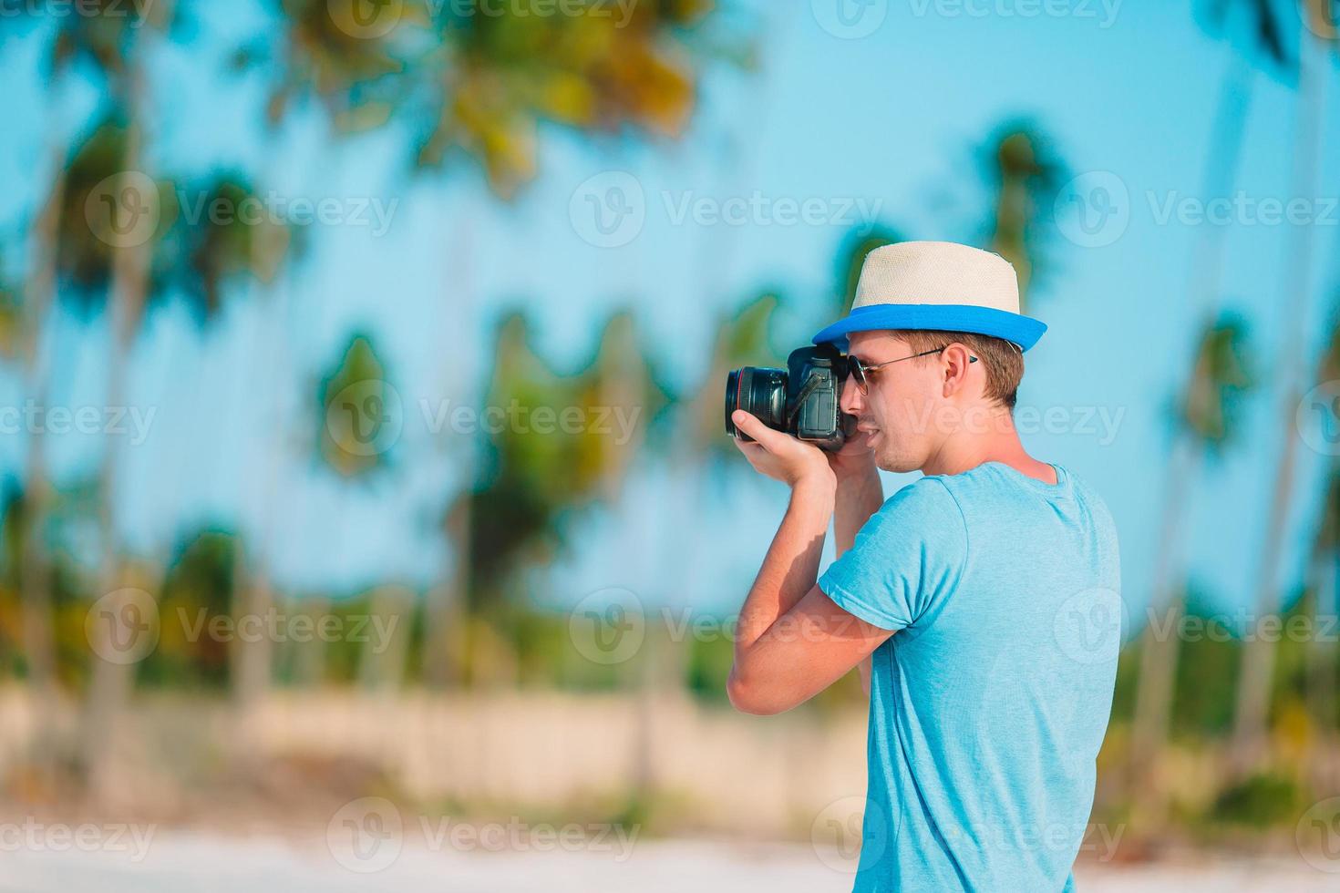 profilo di giovane uomo fotografato bellissimo paesaggio marino su bianca sabbia spiaggia foto