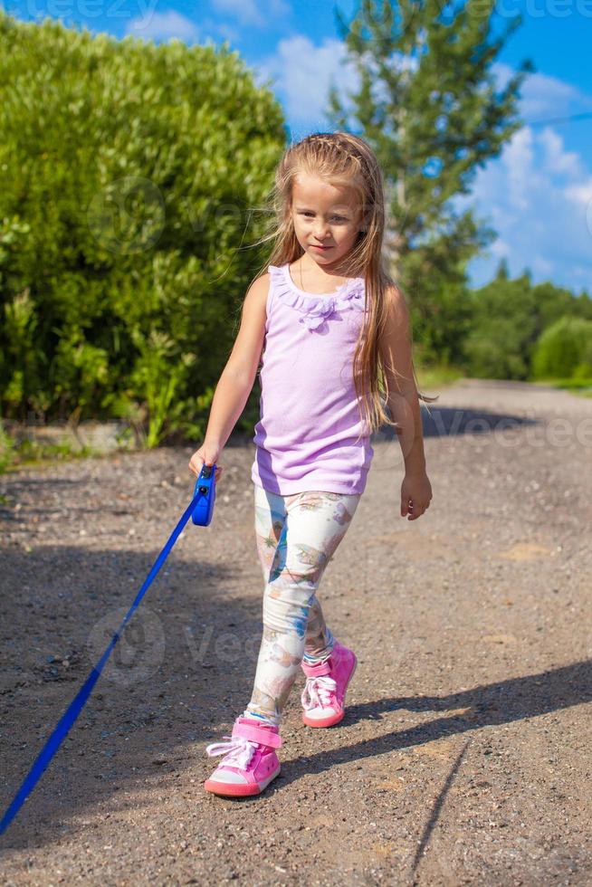 poco ragazza a piedi con sua cane su un' guinzaglio foto