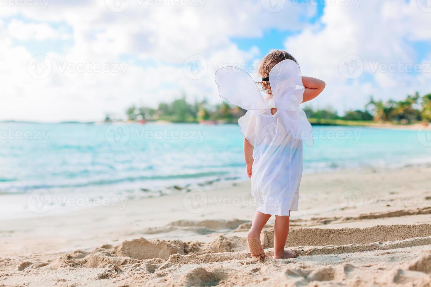 bellissimo giovane ragazza indossare angelo Ali su il spiaggia foto
