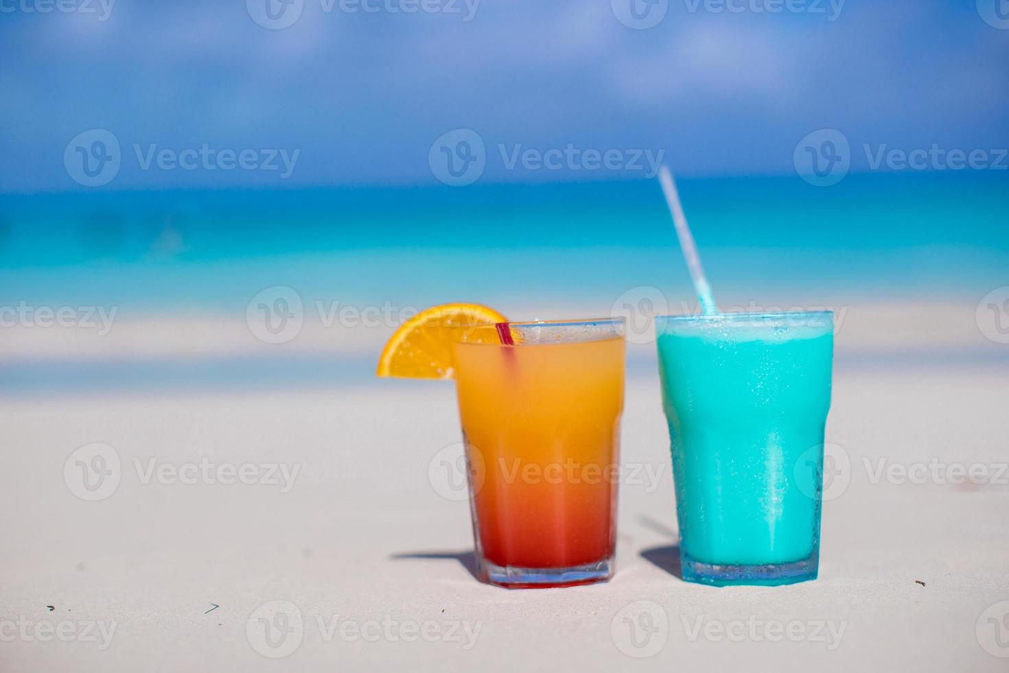 vicino su blu Curacao e Mango cocktail su il bianca sabbioso spiaggia foto