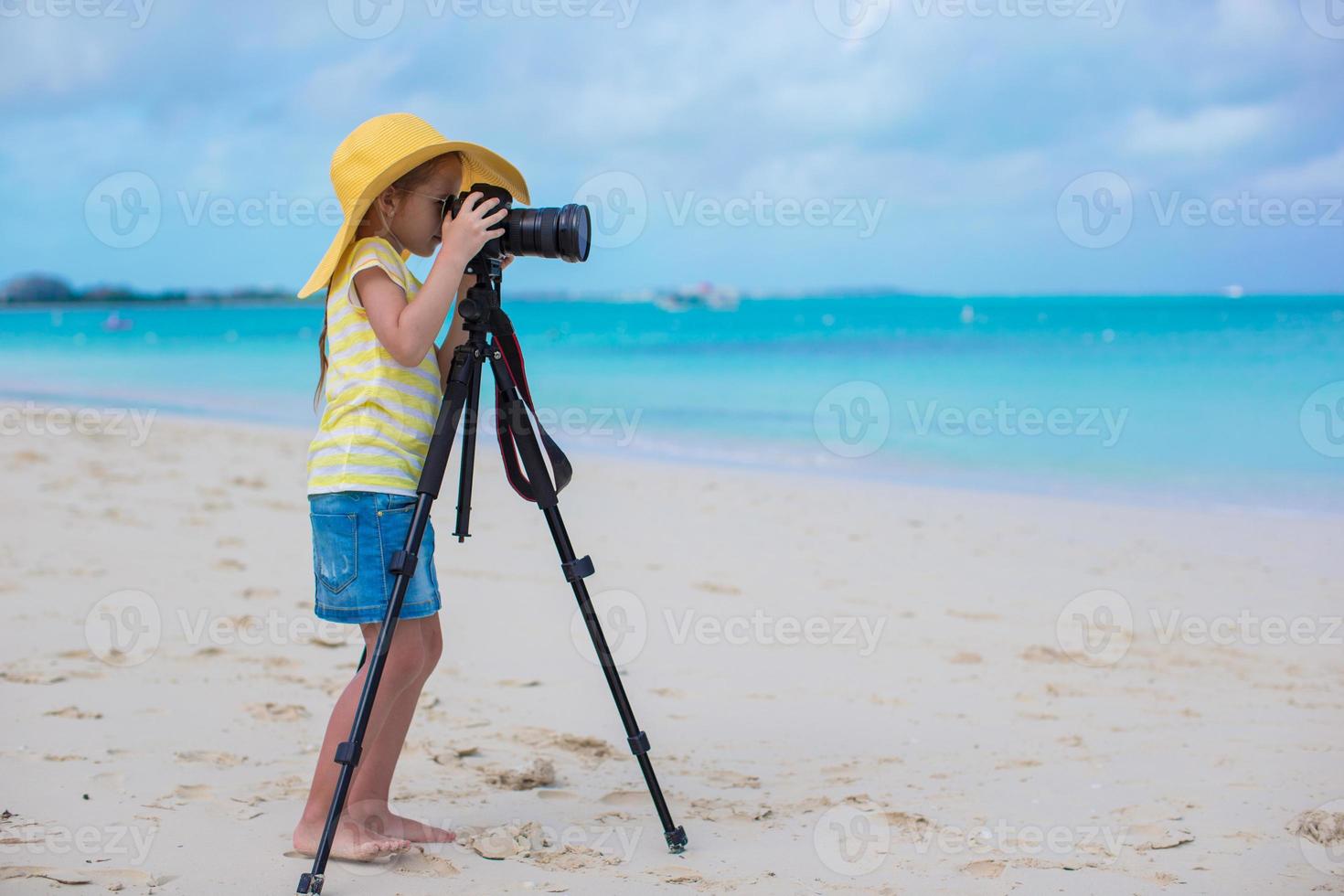 poco ragazza tiro con telecamera su un' tripode durante sua estate vacanza foto