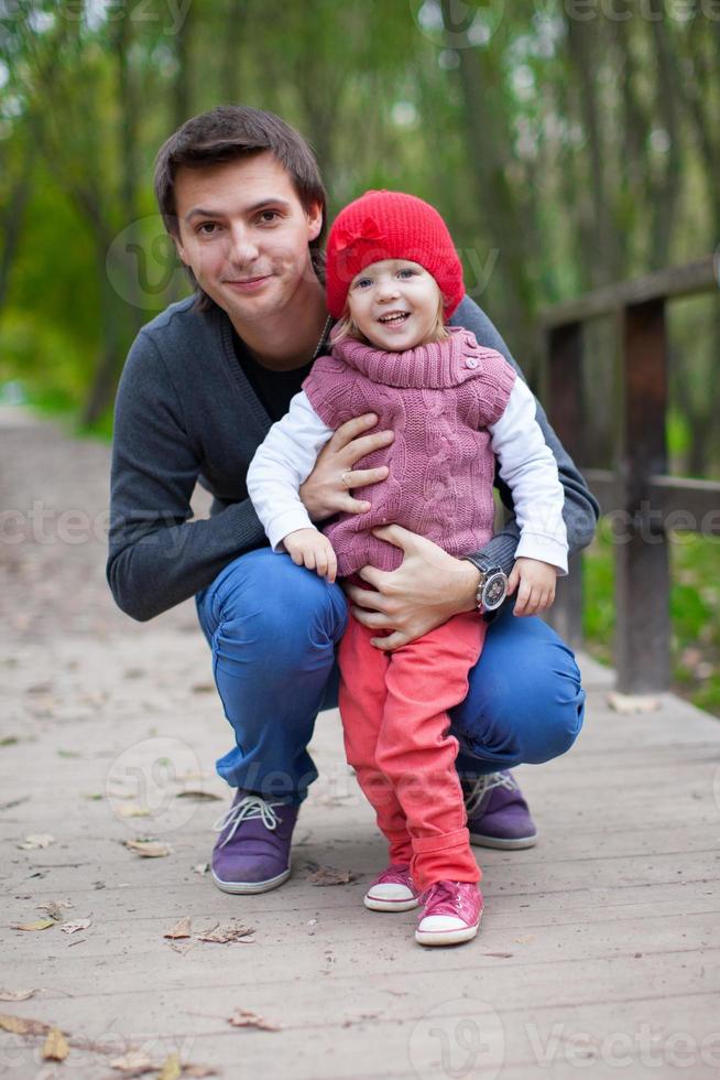 ritratto di contento padre con figlia nel il parco nel autunno foto
