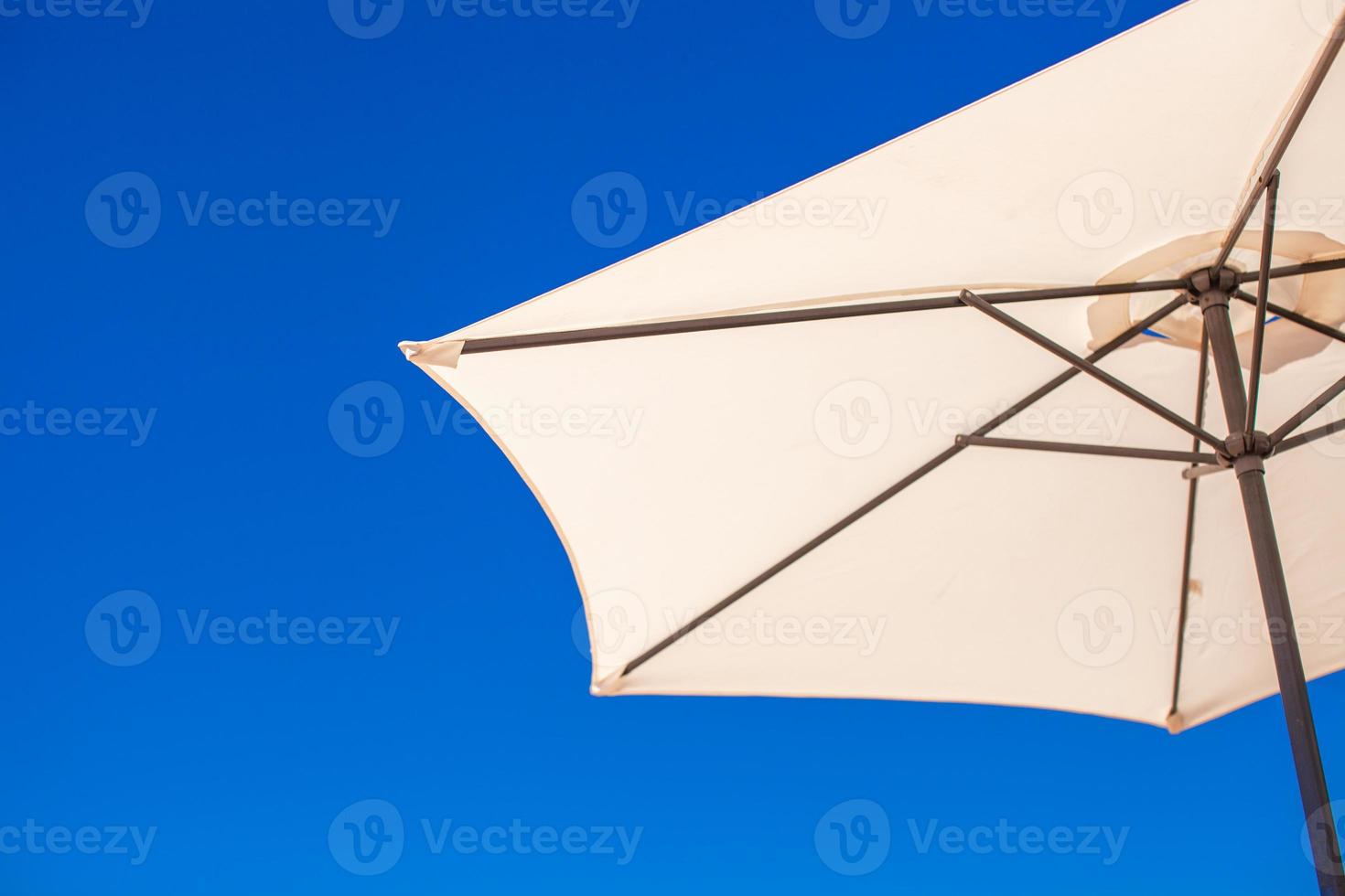parte di bianca ombrello su sfondo blu cielo a il spiaggia foto