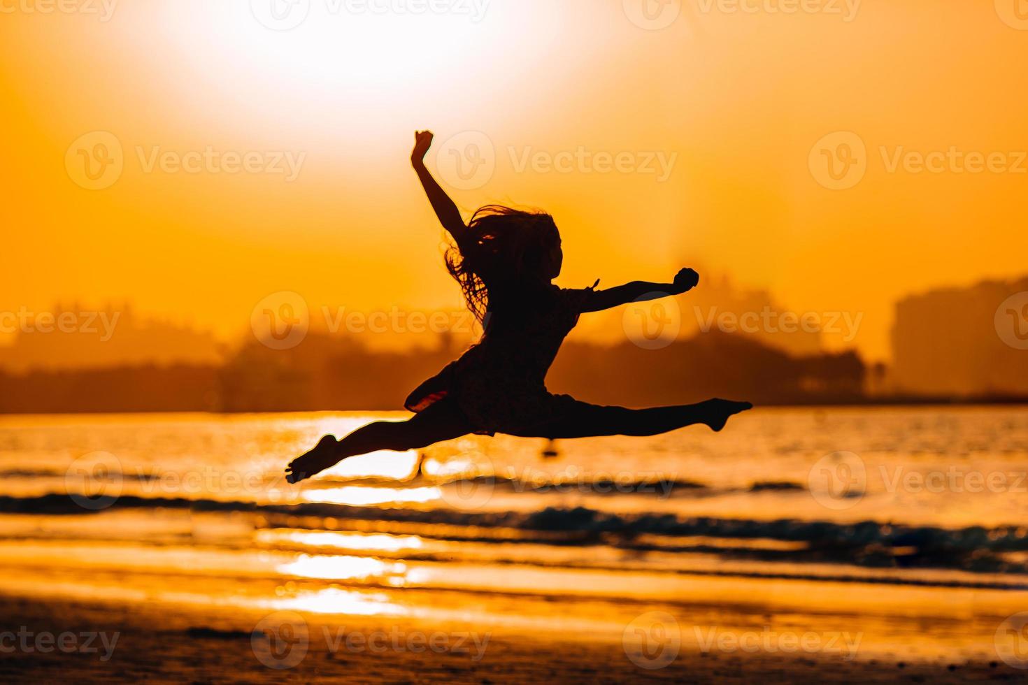 adorabile contento poco ragazza su bianca spiaggia a tramonto. foto