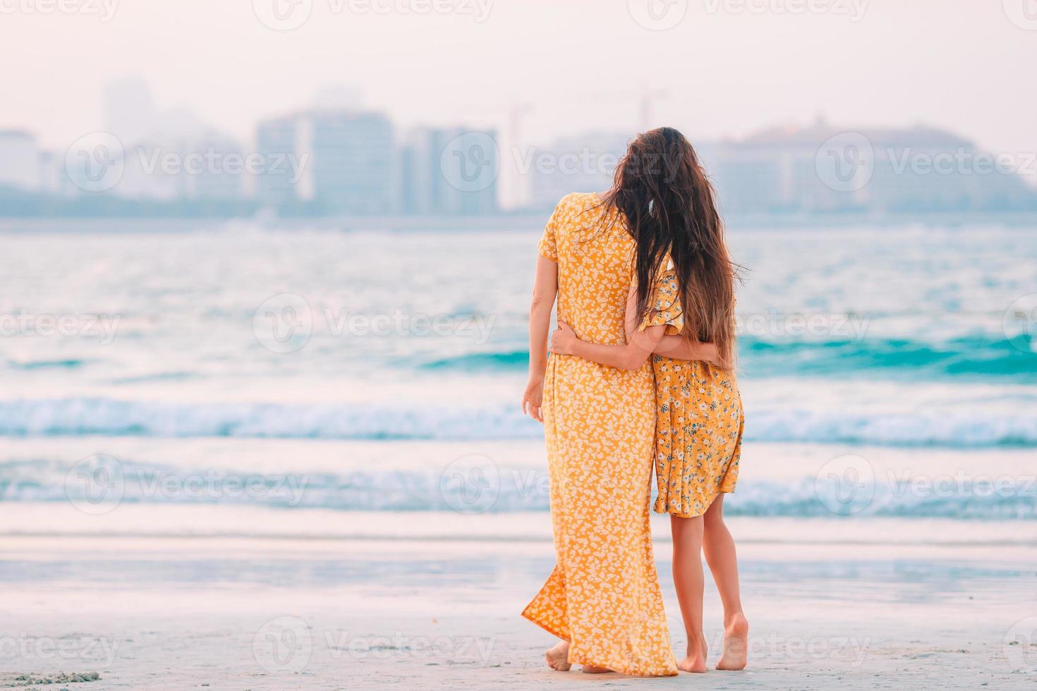 bellissimo madre e figlia a il spiaggia godendo estate vacanza. foto