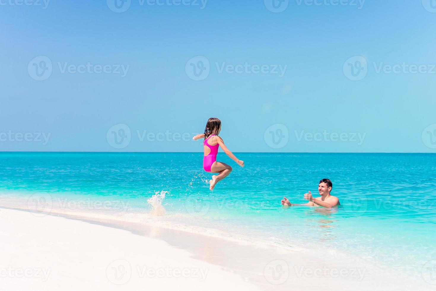 poco ragazza e contento papà avendo divertimento durante spiaggia vacanza foto