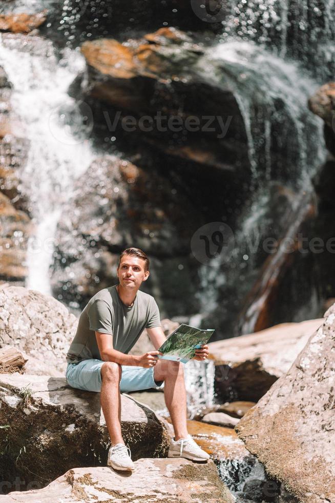 uomo godendo Visualizza di cascata nel gungle foto