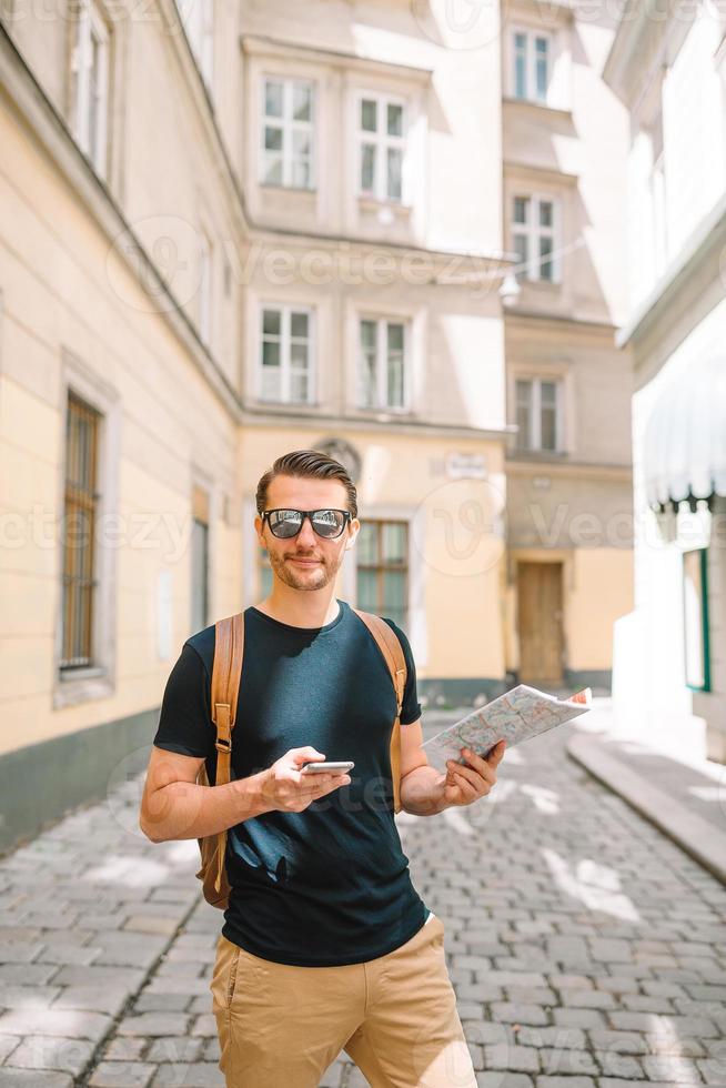 uomo turista con un' città carta geografica e zaino nel Europa strada. foto