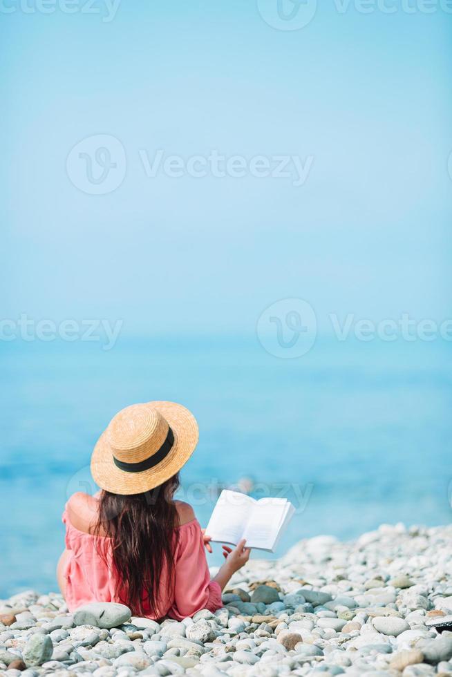 giovane donna lettura libro durante tropicale bianca spiaggia foto