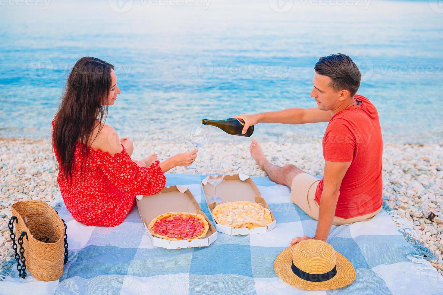 famiglia avendo un' picnic su il spiaggia foto