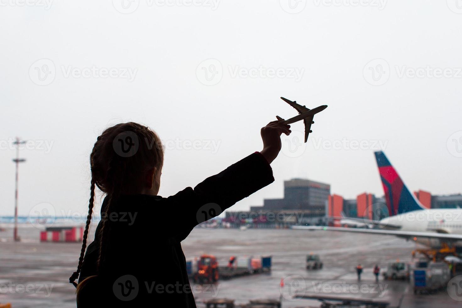 nero silhouette di un' piccolo aereo modello giocattolo su aeroporto nel bambini mani foto