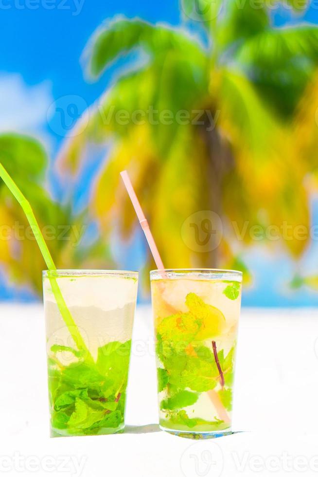 Due freddo gustoso mohito cocktail su il bianca sabbioso spiaggia foto