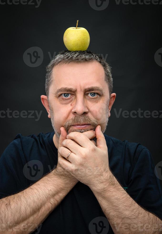 uomo con un' verde Mela su il suo testa foto